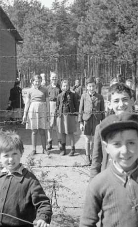 sw-Fotografie: Kindergruppe hinter Stacheldraht