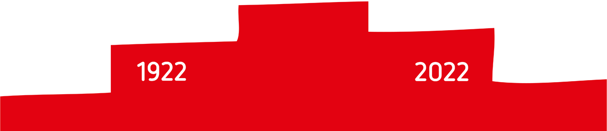 roter Treppengiebel mit weißem Schriftzug: 100 Jahre LüWoBau