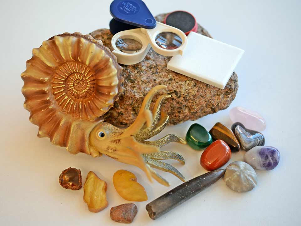 künstlicher Ammonit, Lupe und gesammelte Gesteine, groß