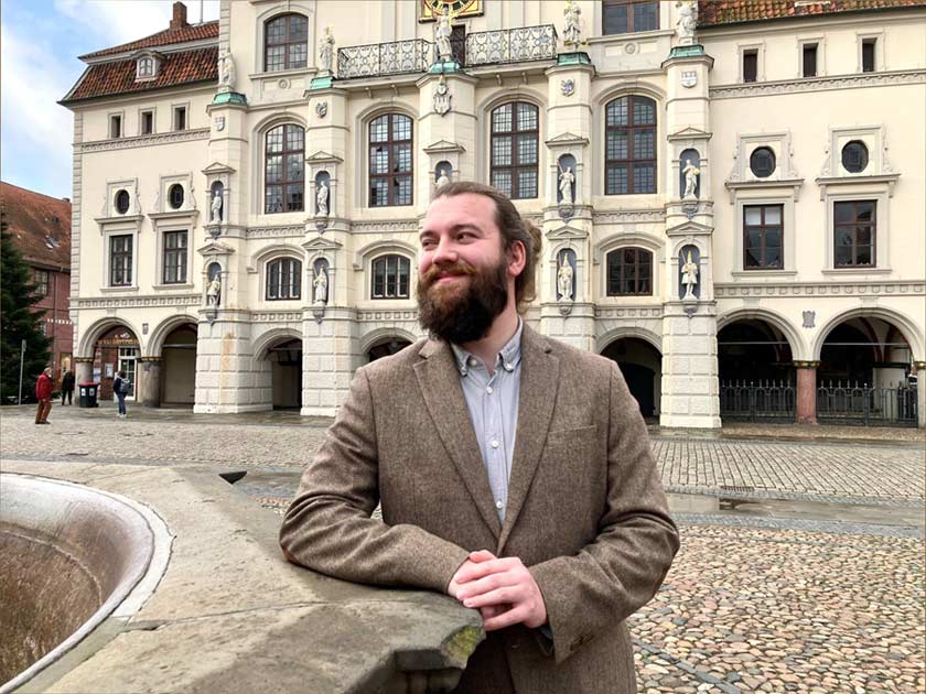 Tobias Schoo lehnt am Lunabrunnen vor dem Rathaus Lüneburg